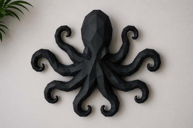 May include: A matte black wall sculpture of an octopus featuring a geometric, faceted design. The creature has a central head and eight radiating, curled tentacles, all constructed with sharp, angular planes that create a low-poly aesthetic.