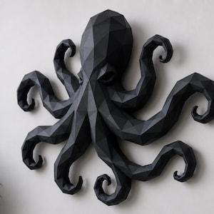 May include: A black wall-mounted octopus sculpture featuring a geometric, low-poly design with sharp, angular facets. The creature has a large central head and eight curved, multi-faceted tentacles extending outward in a symmetrical arrangement.