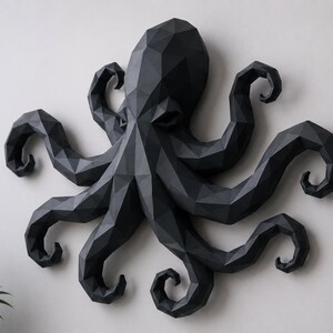 May include: A matte black wall sculpture of an octopus featuring a geometric, low-poly design. The creature has a large central head and eight distinct, curved tentacles extending outward, all constructed from angular, faceted surfaces.