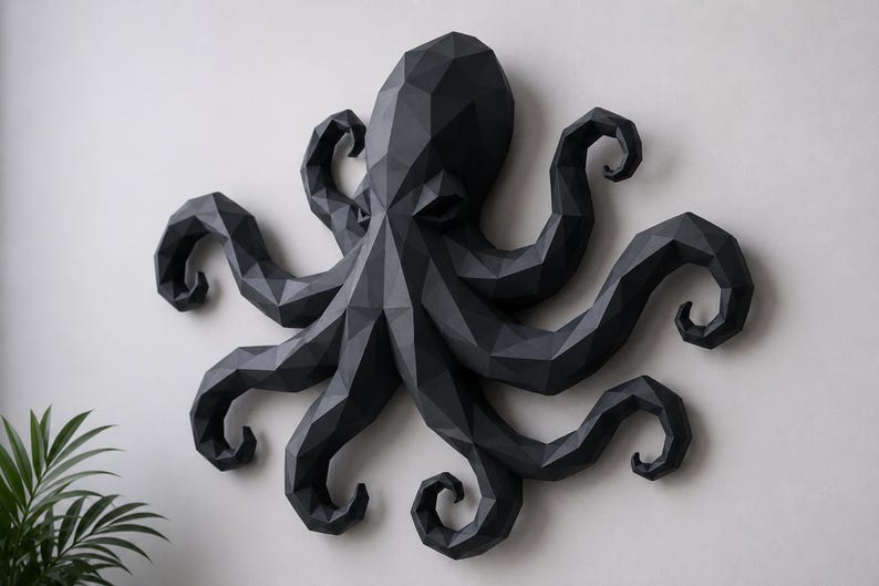 May include: A matte black wall sculpture of an octopus featuring a geometric, low-poly design. The creature has a large central head and eight distinct, curved tentacles extending outward, all constructed from angular, faceted surfaces.