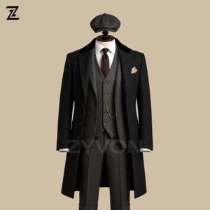 Puede incluir: Un abrigo negro con cuello de terciopelo, un traje de tres piezas gris oscuro que consta de chaleco, pantalón y camisa blanca con corbata marrón, una cadena de reloj de bolsillo dorada y una gorra plana gris oscuro a juego en un maniquí.