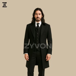 Puede incluir: Un traje negro de tres piezas con un abrigo largo. El traje incluye un chaleco, pantalones de vestir y un abrigo largo con cuello de terciopelo. La marca "ZYVON" es visible en el abrigo. La persona lleva una camisa blanca y una corbata negra.