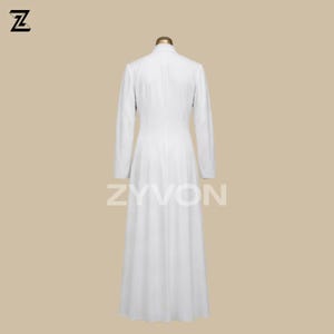 Pu&ograve; includere: Un lungo cappotto bianco con maniche lunghe e collo alto. Il cappotto &egrave; esposto su un manichino. Il nome del marchio "ZYVON" &egrave; stampato in bianco sulla parte inferiore del cappotto. Il cappotto sembra essere realizzato in un tessuto leggero.