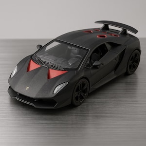 May include: A matte black model car with red accents on the hood and roof. The car has a spoiler and black wheels. The model is a detailed replica of a sports car.