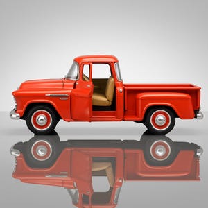 May include: A bright red vintage pickup truck with an open door, revealing a tan interior. The truck has chrome accents, black tires, and red hubcaps. The truck is reflected in the surface below.