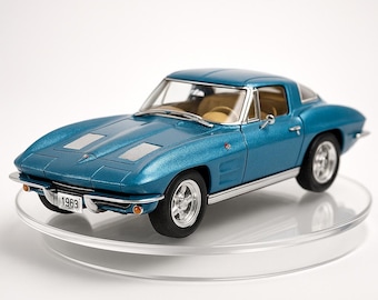 May include: A teal-colored 1963 Corvette model car with a hardtop. The miniature car has a detailed interior, chrome accents, and a license plate that reads "1963". The car is displayed on a clear, circular stand.