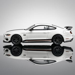 May include: A white sports car with black accents, including black wheels and a black stripe down the hood. The car has a spoiler and the word "MECH" is visible on the side. The car is reflected in a glossy surface.