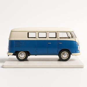 May include: A miniature blue and cream-colored Volkswagen Type 2 bus model. The van has a classic design with a two-tone color scheme, featuring a blue lower body and a cream-colored roof. The model sits on a white base.