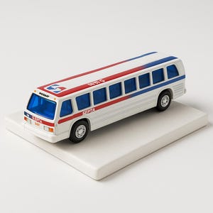 May include: A white toy bus with red and blue stripes and the word "SEPTA" printed on the side. The bus has blue tinted windows and black wheels. The bus is sitting on a white rectangular base.