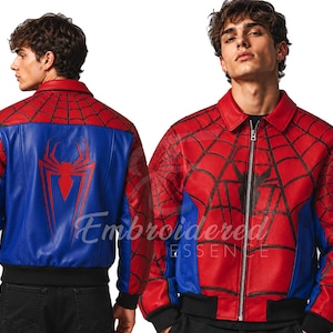 K&ouml;nnte beinhalten: Rote und blaue Spider-Man-Bomberjacke mit schwarzem Kragen und B&uuml;ndchen. Die Jacke hat ein Spinnennetz-Design auf den roten Bereichen und ein gro&szlig;es Spider-Man-Logo auf der blauen R&uuml;ckseite. Mit Rei&szlig;verschluss.