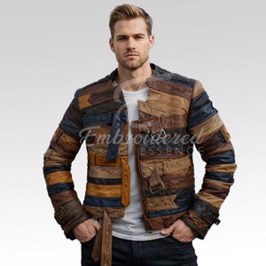 Op de afbeelding: Een patchwork leren jas in bruin, beige en blauw. De jas heeft een uniek ontwerp met horizontale en verticale panelen, een kraag en knoopsluitingen. De merknaam "Embroidered Essence" is zichtbaar op de jas.