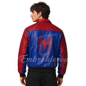 K&ouml;nnte beinhalten: Rote, blaue und schwarze Spider-Man-Bomberjacke. Die Jacke hat ein rotes Spinnennetz-Design auf den &Auml;rmeln und Schultern, mit einem blauen R&uuml;ckenteil, das ein rotes Spinnenemblem zeigt. Schwarzer gerippter Saum und B&uuml;ndchen.