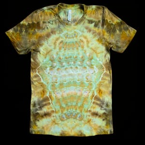 May include: A short-sleeved t-shirt with a tie-dye pattern in shades of brown, yellow, and green. The shirt has a crew neck and a symmetrical design in the center. The fabric appears to be soft and comfortable.