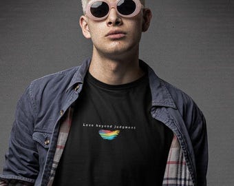 Puede incluir: Una camiseta negra con el texto Love beyond judgment y un pequeño gráfico de arcoíris, combinada con una camisa azul de forro a cuadros, vaqueros azul claro, cinturón marrón y botas negras, junto con gafas de sol redondas de tono rosa.