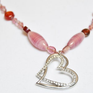 Red and Pink glass handmade beads holding a double heart in silver and crystals.