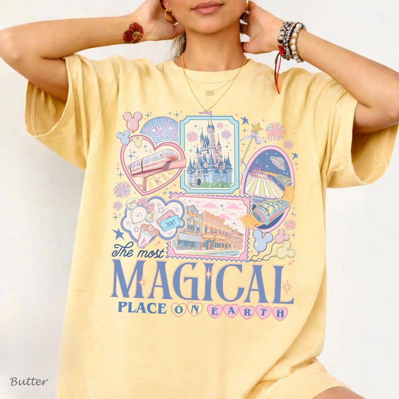 Pu&ograve; includere: T-shirt giallo burro con un design grafico colorato. Il design include illustrazioni di un castello, una monorotaia e altri elementi del parco a tema, con la scritta "The most MAGICAL PLACE ON EARTH".