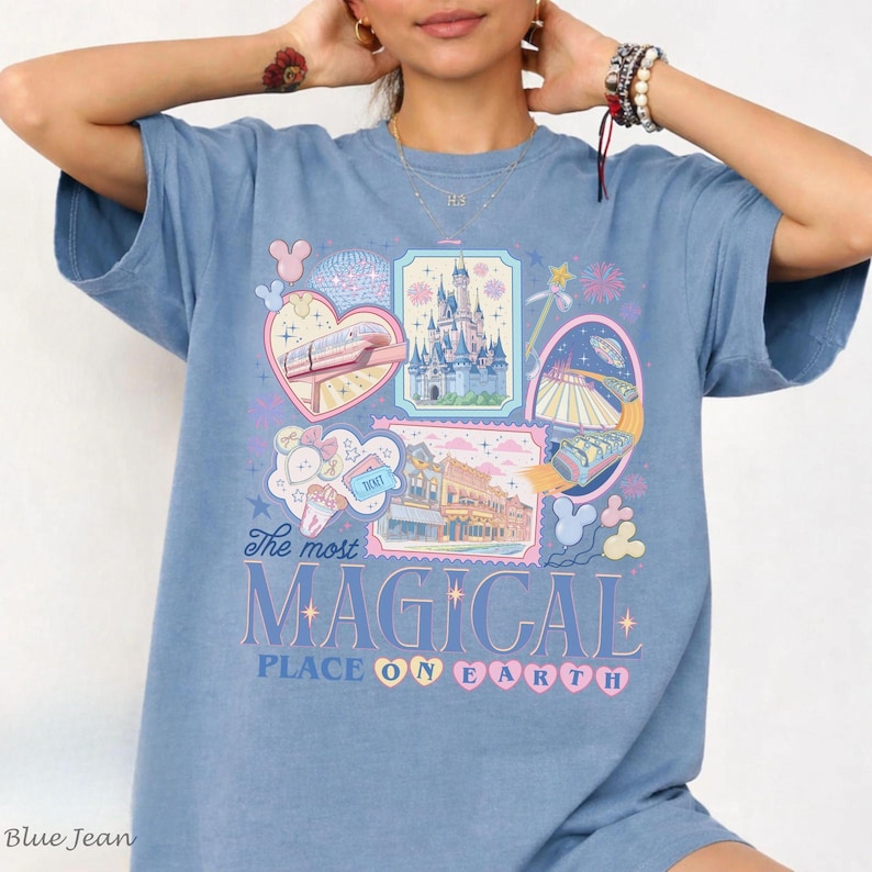 Pu&ograve; includere: T-shirt blu jeans con un design grafico colorato. Il design presenta un cuore con un treno, un castello e le parole "The most MAGICAL PLACE ON EARTH" in un carattere stravagante. La maglietta &egrave; uno stile comodo e casual.