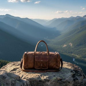 May include: A brown leather duffel bag featuring two top handles, a detachable shoulder strap, and a central front pocket with a buckle closure. The bag has a rectangular shape with side zippers and metal hardware accents on the handle attachments.