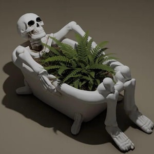 Peut inclure: Un squelette blanc se relaxant dans une jardinière en forme de baignoire, remplie de fougères vertes. Le squelette a un crâne détaillé et est posé avec ses bras sur la baignoire. Un objet décoratif unique.