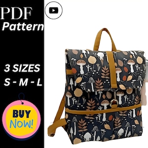 Könnte beinhalten: Ein schwarzer Rucksack mit einem Pilz- und Blättermuster, mit braunen Riemen und Akzenten. Die Tasche hat einen Klappverschluss und einen oberen Griff. Der Text auf dem Bild lautet "PDF Pattern" und "3 SIZES S-M-L". Ein "Buy Now!"-Button ist ebenfalls sichtbar.