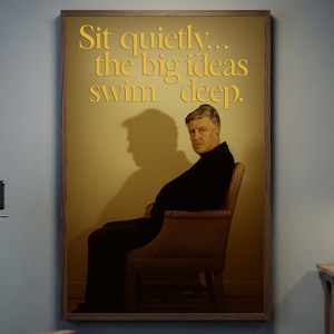 Op de afbeelding: Een ingelijste poster met de tekst "Sit quietly... the big ideas swim deep." toont een man die in een stoel zit. De poster bevindt zich in een kamer met een vintage filmcamera en een regisseursstoel.