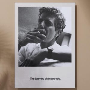 May include: Black and white print featuring a man smoking a cigarette. The man is wearing a white shirt and has curly hair. The text "The journey changes you." is printed at the bottom of the print.