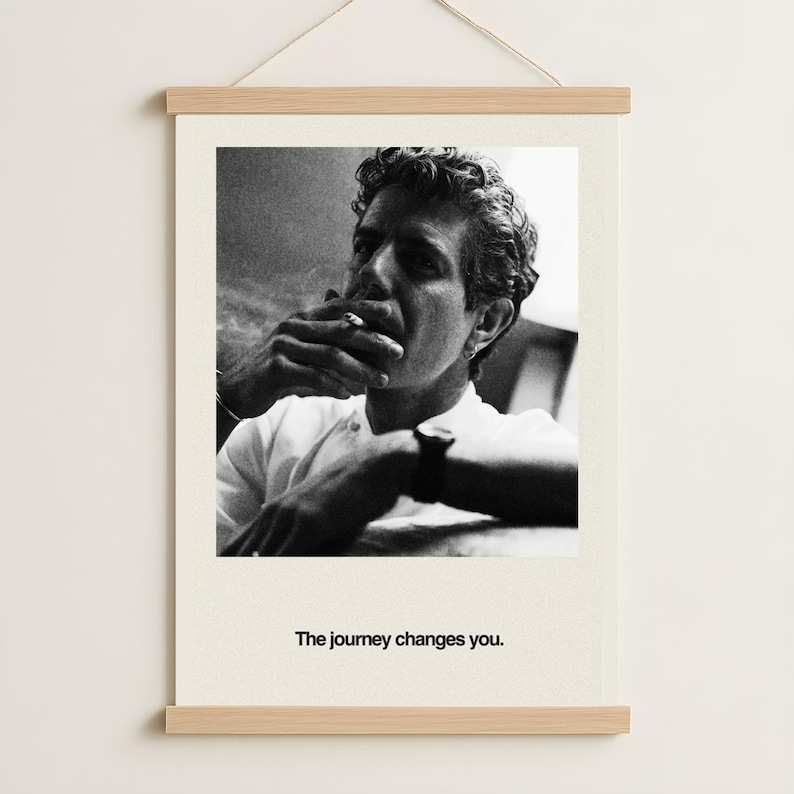 May include: Black and white photograph print of a person smoking a cigarette. The person is wearing a white shirt and has curly hair. The print is mounted on a wooden frame with the text "The journey changes you."