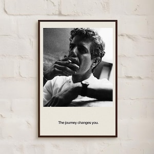 May include: Black and white framed print featuring a man smoking a cigarette. The man is wearing a white shirt and a watch. The text "The journey changes you." is printed at the bottom of the print.