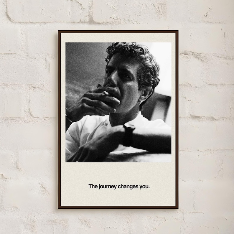 May include: Black and white framed print featuring a man smoking a cigarette. The man is wearing a white shirt and a watch. The text "The journey changes you." is printed at the bottom of the print.