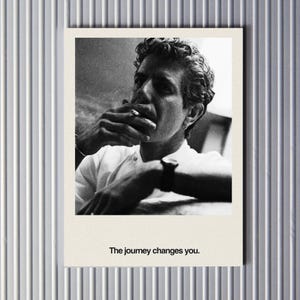 May include: Black and white photograph of a man smoking a cigarette, with the text "The journey changes you." The image is a portrait, with the man's face and upper body visible. The photograph is on a cream-colored background.