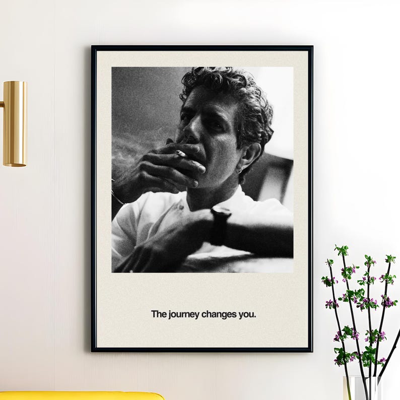 May include: Black and white framed print featuring a man smoking a cigarette. The man is wearing a white shirt and a watch. The print includes the text "The journey changes you."