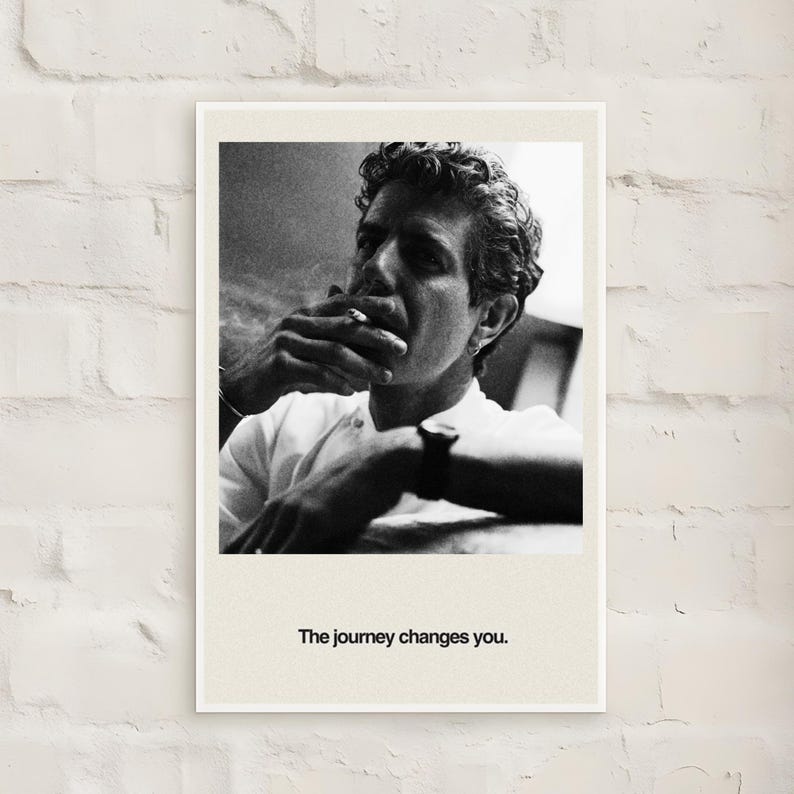 May include: Black and white framed print featuring a man smoking a cigarette. The man is wearing a white shirt and a watch. The text "The journey changes you" is printed at the bottom of the print.