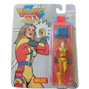 May include: A Bionic Six Helen action figure in original packaging. The card features a colourful illustration of the character Helen with the text Bionic Six. The plastic blister pack contains the Helen figure in a yellow and red suit with a blue accessory.