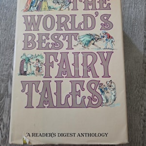 Puede incluir: Un libro de tapa dura titulado The World's Best Fairy Tales: A Reader's Digest Anthology. La cubierta de color crema presenta texto en color púrpura y múltiples ilustraciones coloridas de personajes de cuentos de hadas, incluyendo realeza, niños y criaturas.