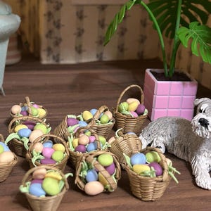 May include: A collection of miniature wicker baskets filled with colorful pastel Easter eggs. The baskets are arranged on a wooden surface with a small gray dog figurine nearby.