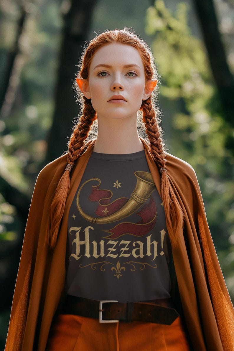 Medieval fantasy Huzzah shirt worn by elf-inspired woman at renaissance fair woods cosplay.