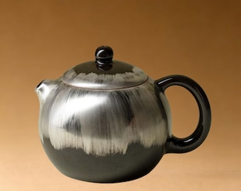 Tetera artesanal de cerámica negra con baño de plata y capacidad de 100 ml.
