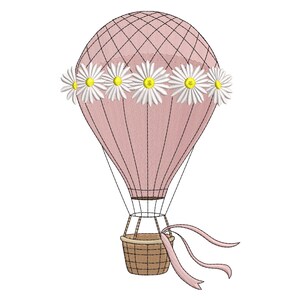 Puede incluir: Un globo aerostático rosa con una corona de flores de margarita y una cesta tejida. El globo tiene un patrón de diamantes y líneas negras. Cintas rosas salen de la cesta. Las margaritas tienen pétalos blancos y centros amarillos.