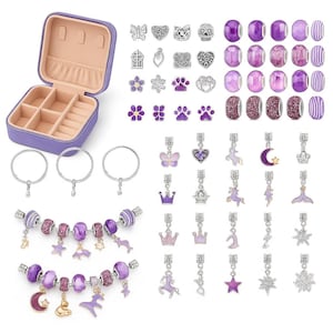 Könnte beinhalten: Eine offene, lila Schmuckschatulle mit verschiedenen Charms, Perlen und Armbändern. Die Charms umfassen Schmetterlinge, Herzen und Kronen. Die Perlen sind lila und die Armbänder sind mit Charms verziert. Das Set ist für die Schmuckherstellung konzipiert.
