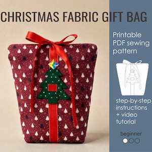 May include: A maroon fabric gift bag featuring a white Christmas tree pattern, tied with a red ribbon. A green felt Christmas tree applique with a holographic star is centered on the front. Text includes CHRISTMAS FABRIC GIFT BAG, Printable PDF sewing pattern, step-by-step instructions + video tutorial, and beginner.