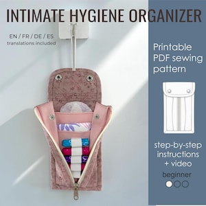 Puede incluir: Un organizador de higiene íntima de tela colgante con estampado floral, que cuenta con cierre de broche, bolsillos internos y bucles elásticos para varios productos. El texto dice INTIMATE HYGIENE ORGANIZER, Printable PDF sewing pattern, y step-by-step instructions + video.