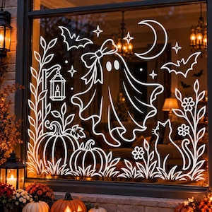 May include: A white vinyl window decal featuring a ghost with a bow, two pumpkins, a cat, bats, a crescent moon, stars, flowers, and a lantern. The design is composed of clean white lines applied to a glass surface, creating a festive display.