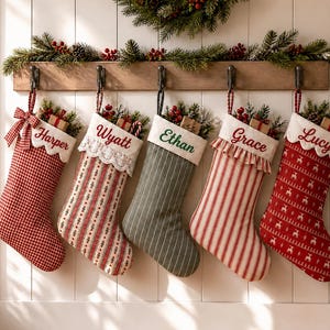 May include: Five Christmas stockings hanging on a wooden rack. The stockings feature various patterns including red gingham, striped, and reindeer prints, with white cuffs embroidered with the names Harper, Wyatt, Ethan, Grace, and Lucy.