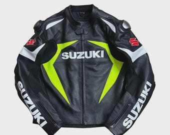 May include: Black leather motorcycle jacket with the word "SUZUKI" in white across the chest and sleeves. The jacket features neon green and white accents, along with the Suzuki logo in red and white on the shoulders.