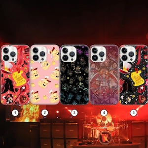 May include: Five phone cases with unique designs. The cases feature various patterns, including cartoon characters, gothic illustrations, and a stained-glass style. Colors range from pink and black to red and purple. Each case has a camera cutout.