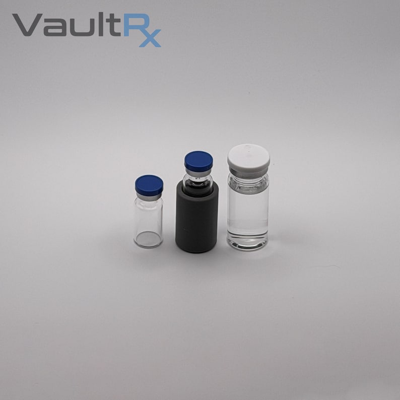 May include: Three glass vials with blue and white caps. One vial is in a black holder. The vials are empty and clear. The text "VaultRx" is in the upper left corner.