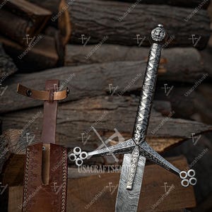 May include: A silver sword with an elaborate handle and crossguard, and a brown leather sheath. The blade has a unique pattern. The background features stacked wooden logs. The sword is a symbol of power.