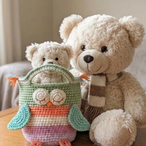 May include: A handmade crochet owl-shaped bag with a handle, featuring green, orange, purple, and blue stripes. Two plush teddy bears are behind the bag. The larger bear wears a striped scarf. The items are on a wooden surface.