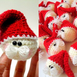 Op de afbeelding: Een groep gehaakte kerstman-versieringen met witte baarden en rode mutsen. De versieringen zijn gemaakt van wit en rood garen.