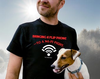 May include: Black t-shirt with the text "BRINGING A FLIP PHONE...TO A WI-FI FIGHT." and a Wi-Fi symbol. A Jack Russell Terrier dog is held in the arms of a person. The dog has white and brown fur and is wearing a blue collar.